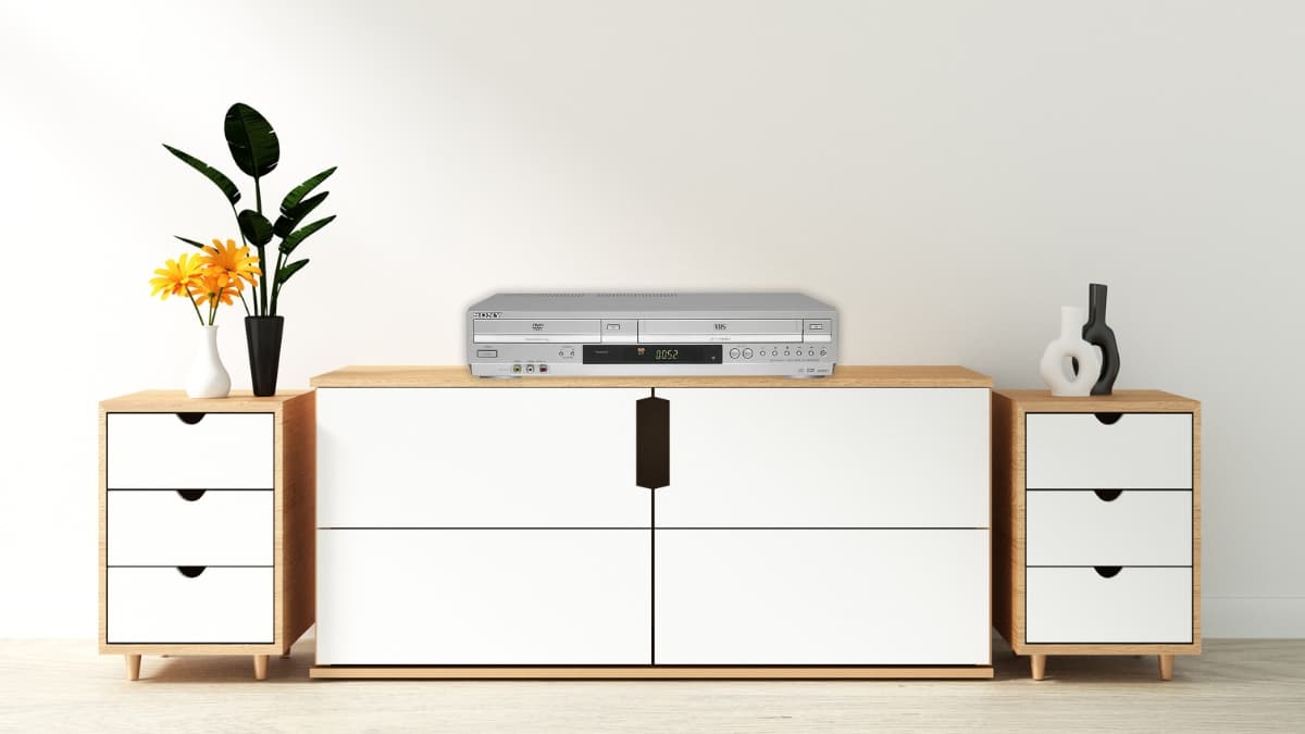A Sony VHS DVD combo player sits on a modern white media cabinet between two drawer units.