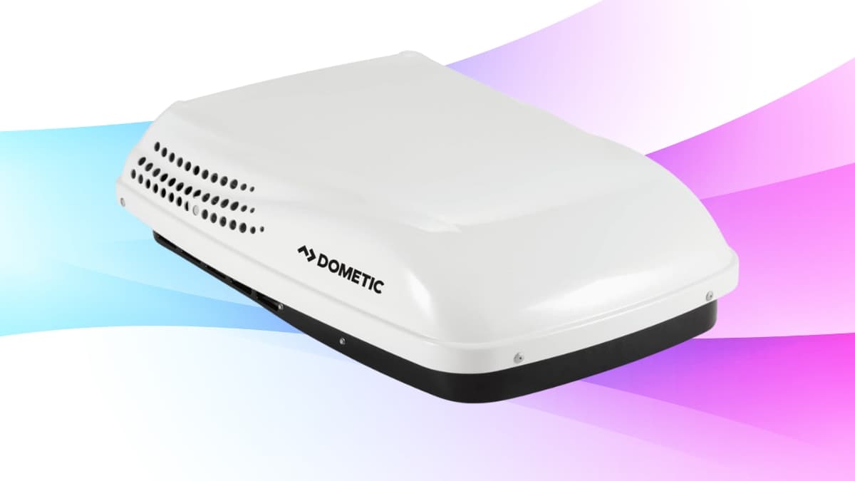 Close-up of a Dometic Penguin II rooftop air conditioner unit with a colorful background.
