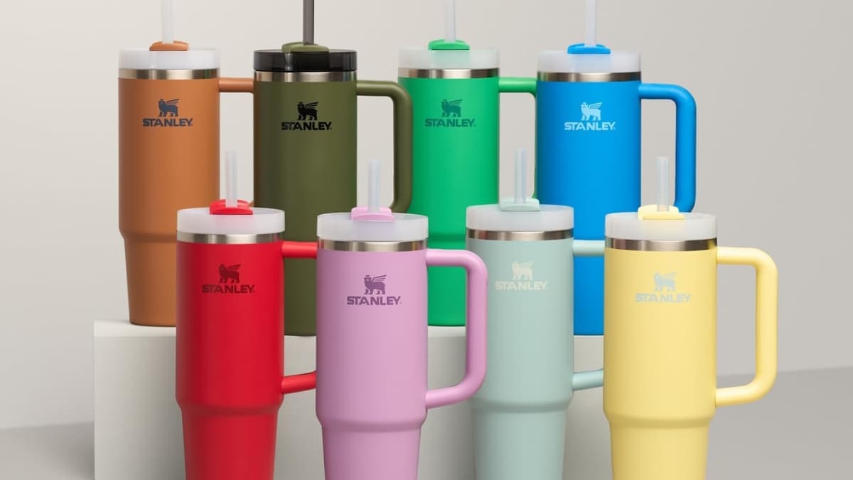 A colorful set of STANLEY Quencher tumblers stands in a row, showing different bright shades and the handled design with straws.